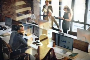 Marketing communications team working at their desks, collaborating to cover all bases. The team is working on marketing communications, crisis management, communications strategy, litigation support, media relations and public relations (PR). 