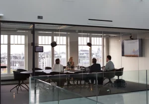 Communications team meeting in a conference room, potentially discussing communications strategy, change management, internal communication & messaging, marketing, teams transformation and/or corporate communications.